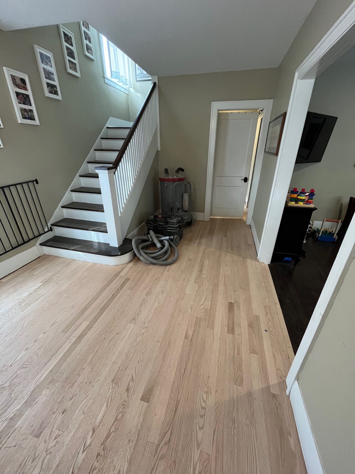 Finished hardwood flooring through a home entry and staircase