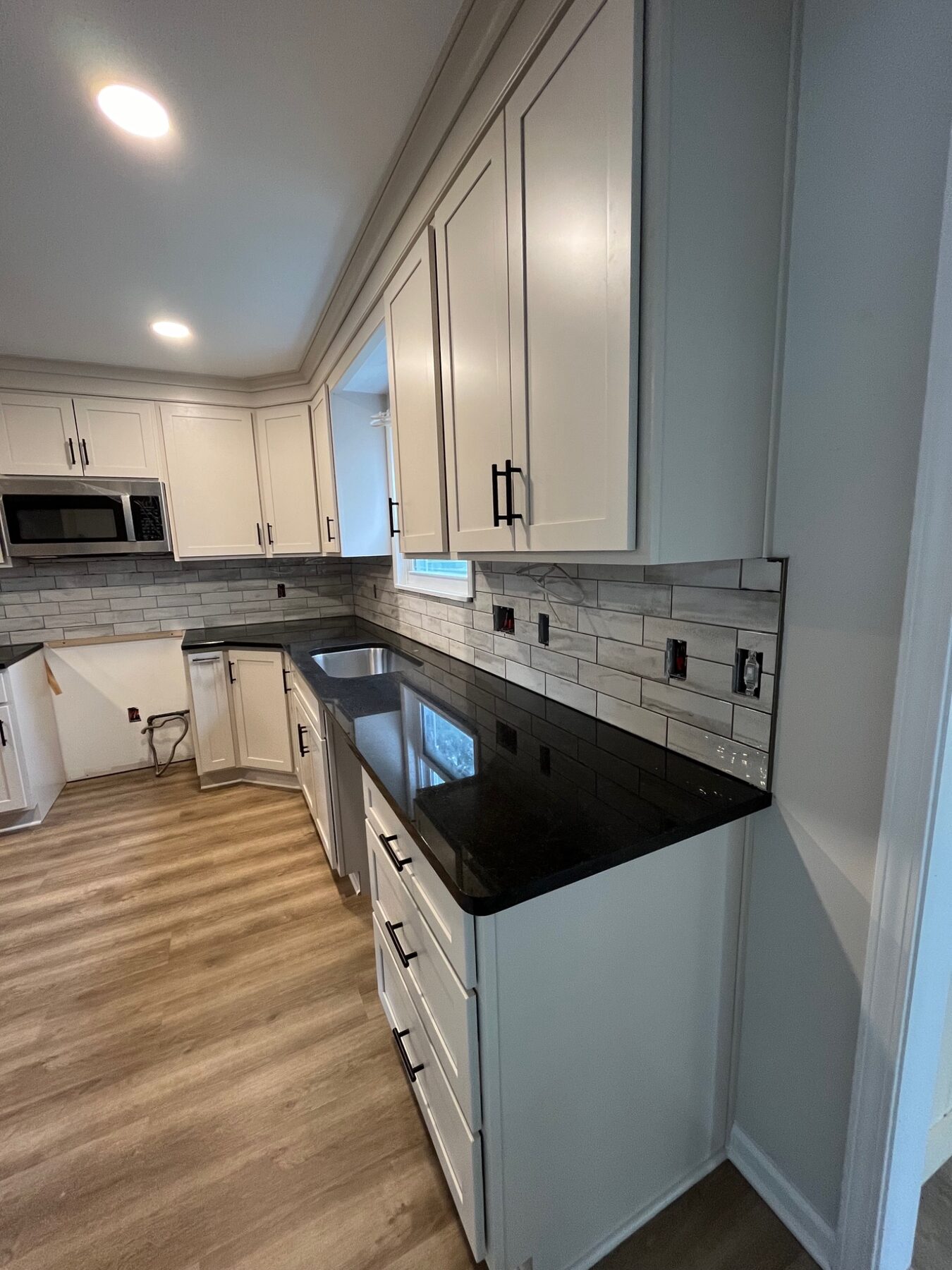 White kitchen with a finished gray subway tile backsplash