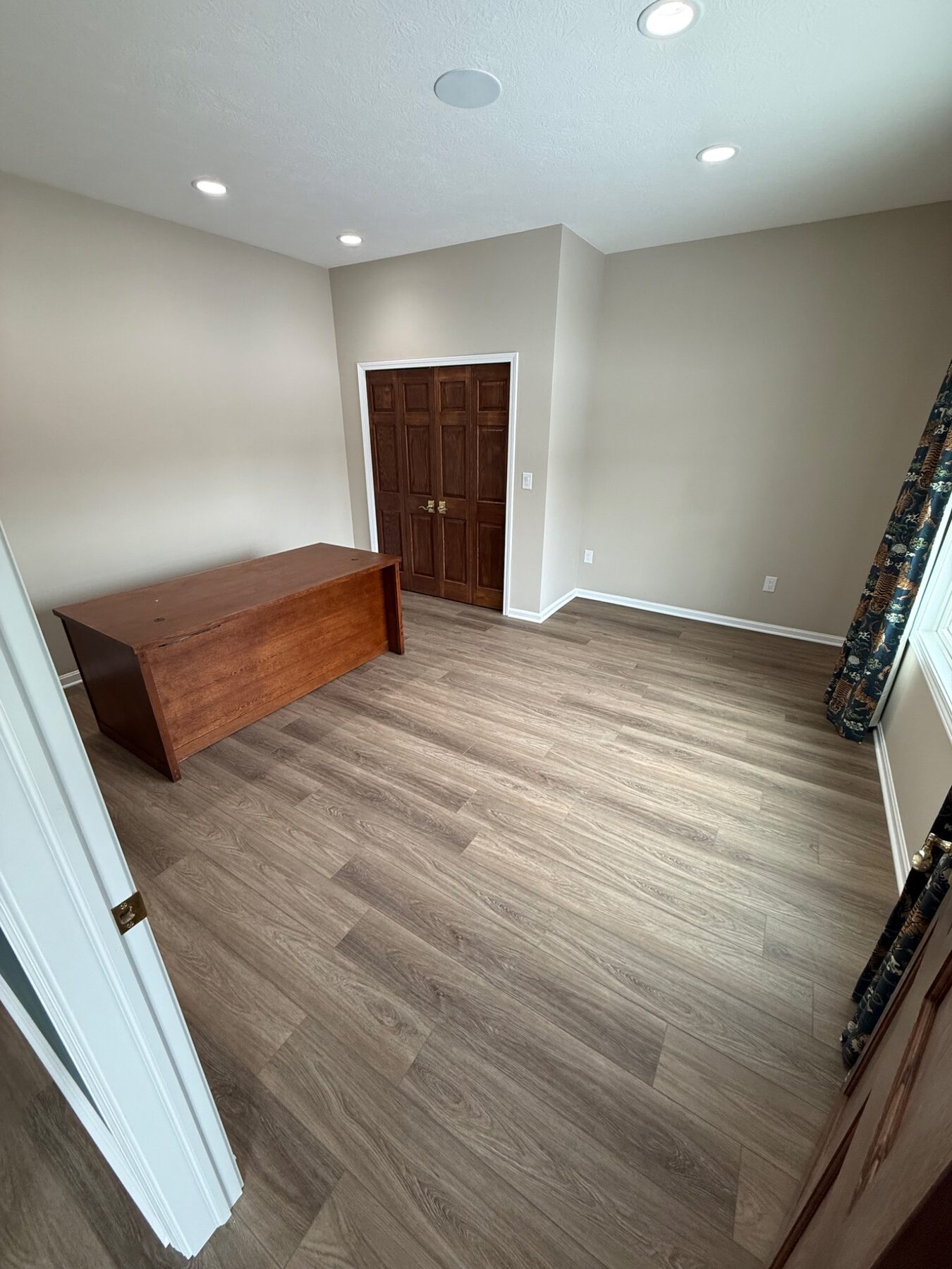 Finished room with new luxury vinyl plank flooring and crisp white trim